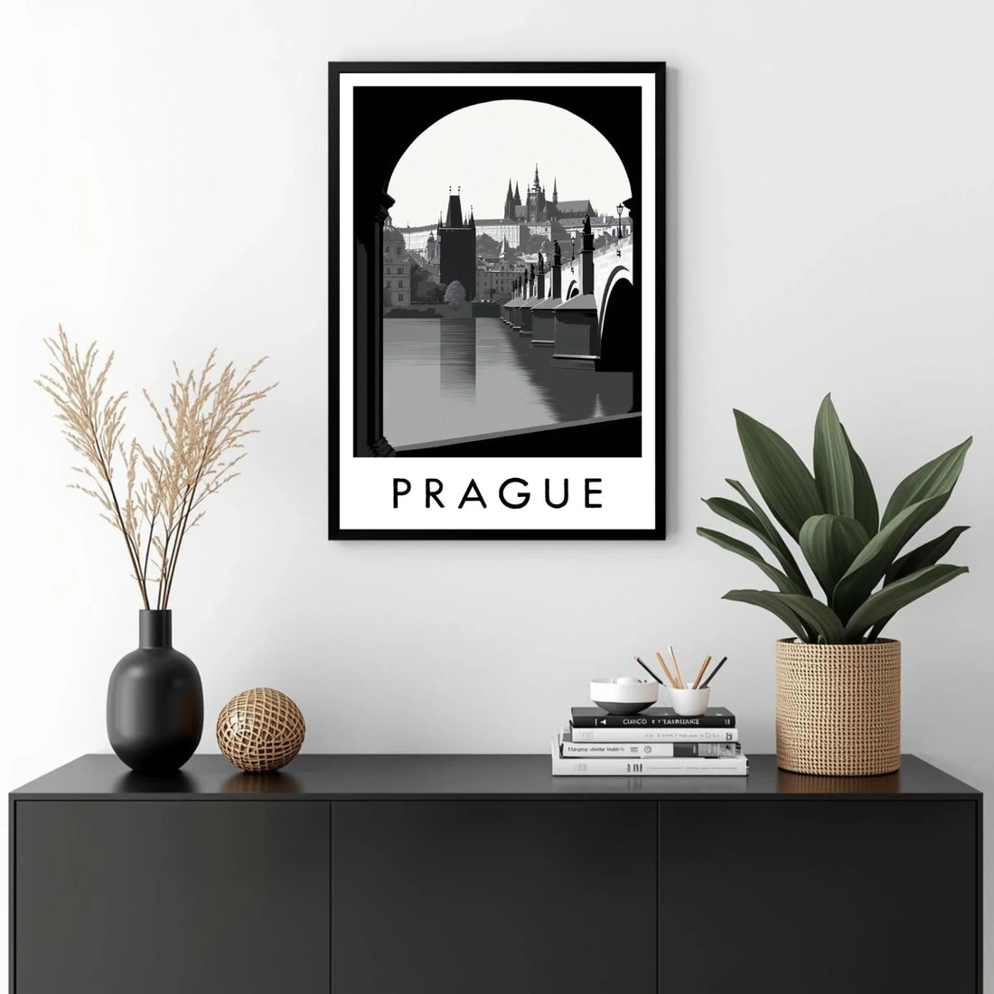 Framed artwork of Prague on a wall above a black cabinet with decorative items.