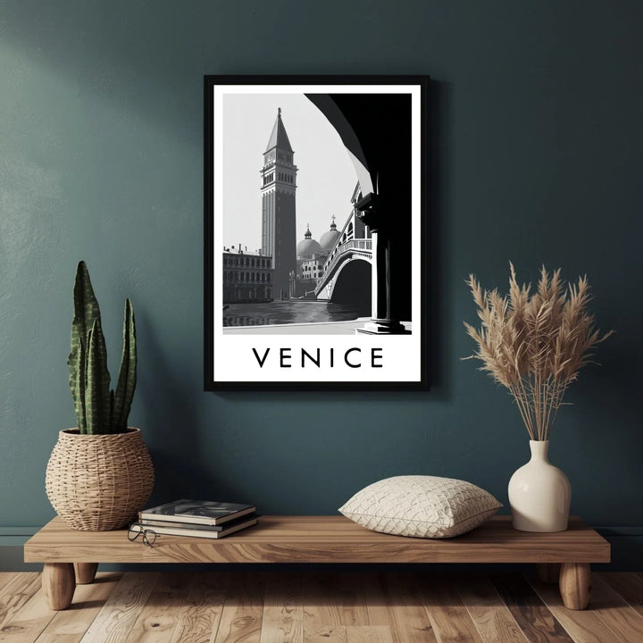Framed Venice print on a wall above a wooden shelf with decorative items.