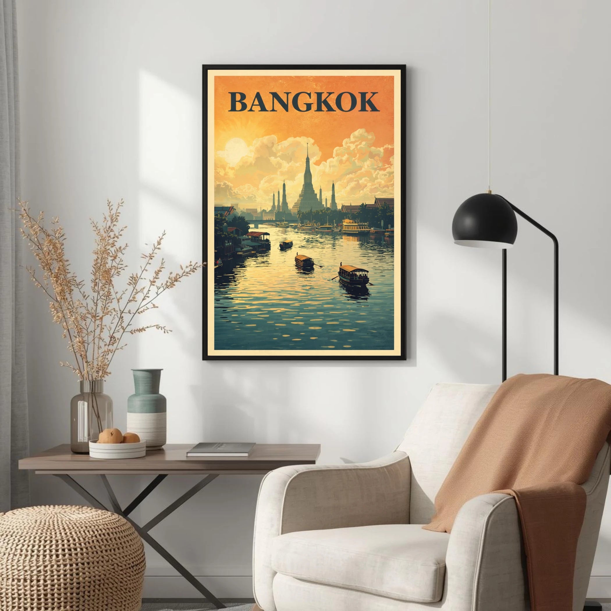 Framed poster of Bangkok on a wall above a white armchair with a lamp and small table.