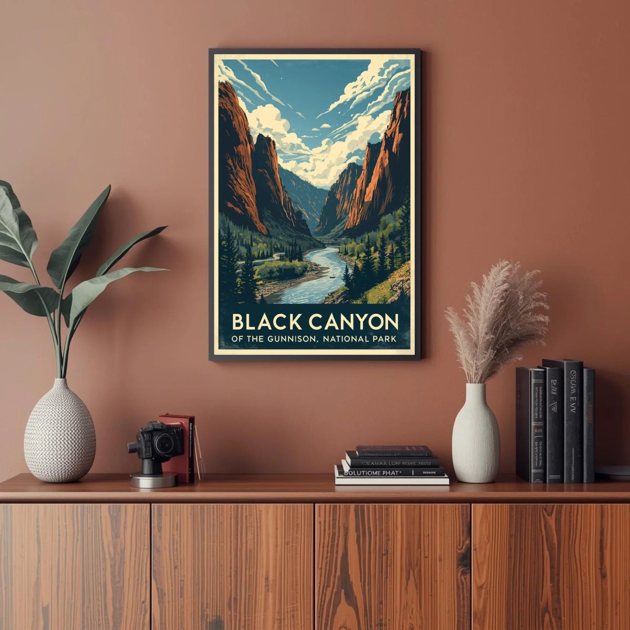 Framed poster of Black Canyon of the Gunnison National Park on a wall above a wooden cabinet with decor items.