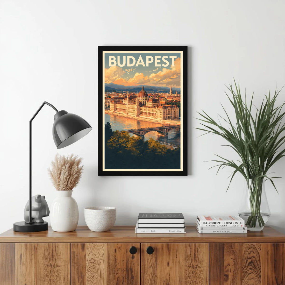 Framed poster of Budapest on a wall above a wooden cabinet with decor items.