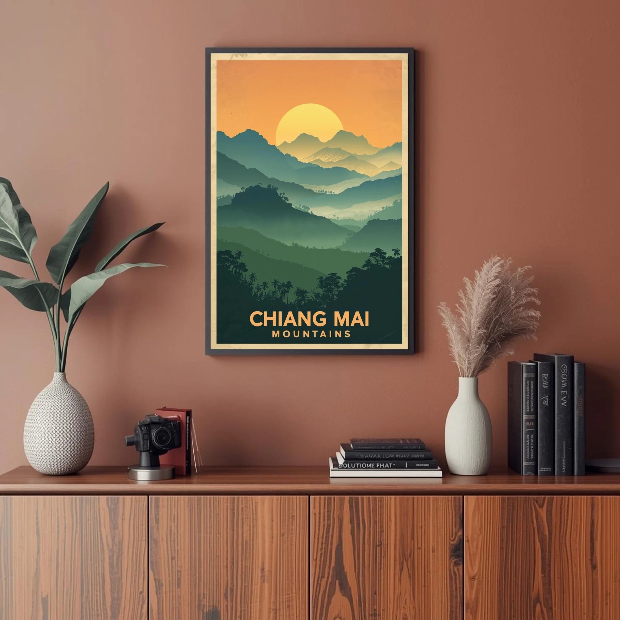 Framed poster of Chiang Mai mountains on a wall above a wooden cabinet with decor items.