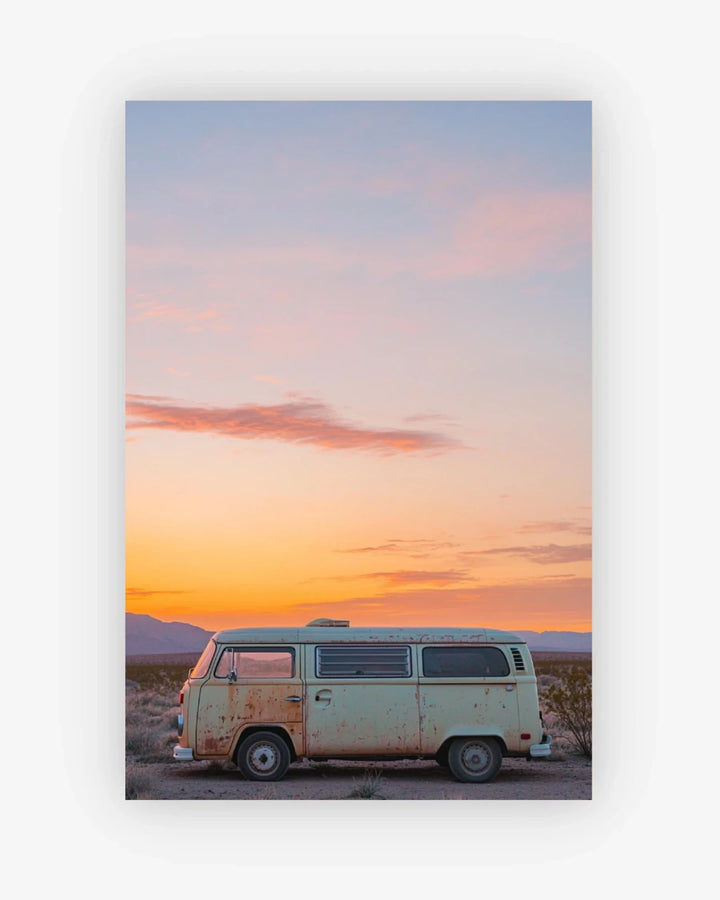 Vintage van parked in a desert landscape with a colorful sunset sky.