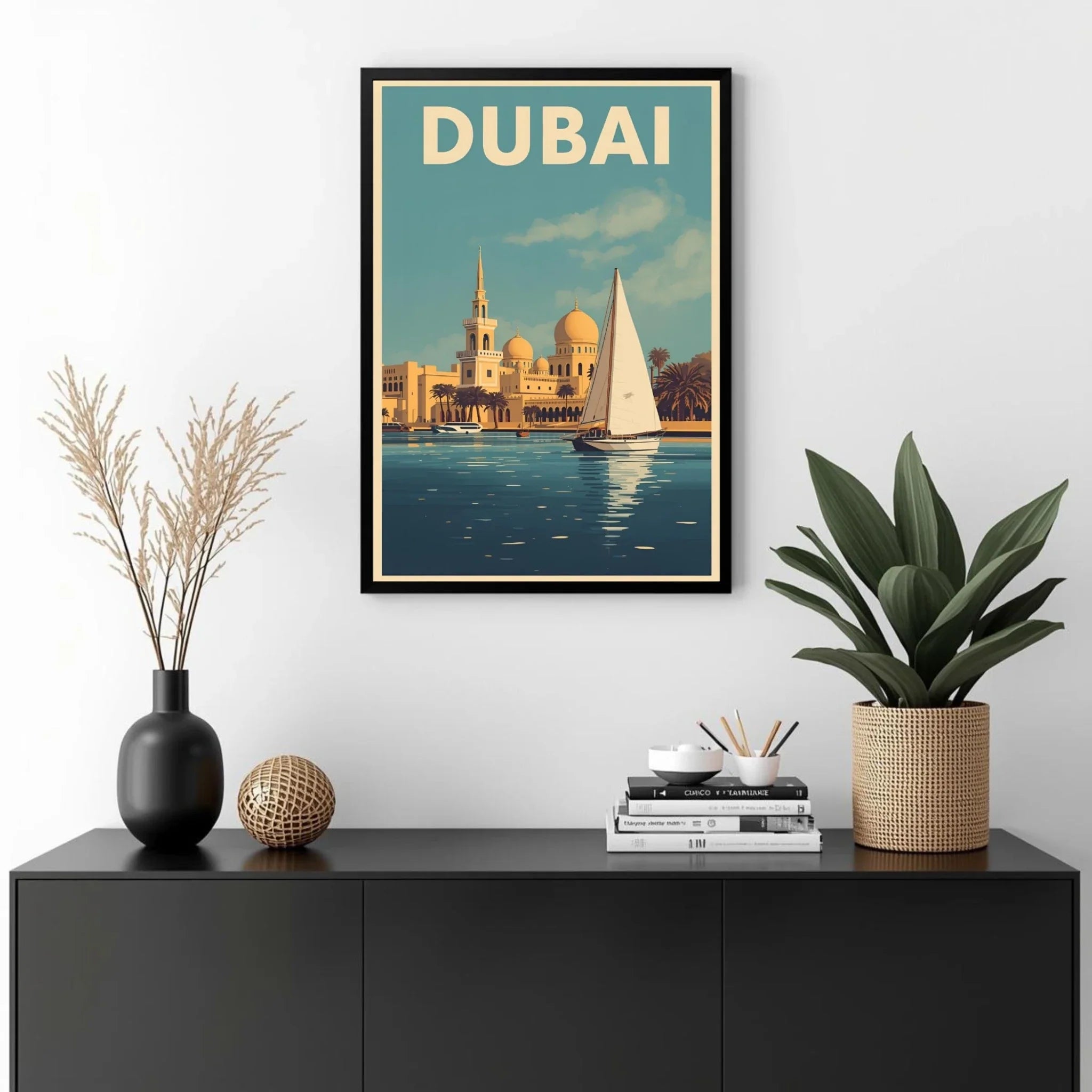 Framed poster of Dubai with a sailboat and cityscape, displayed on a wall above a black cabinet with decorative items.