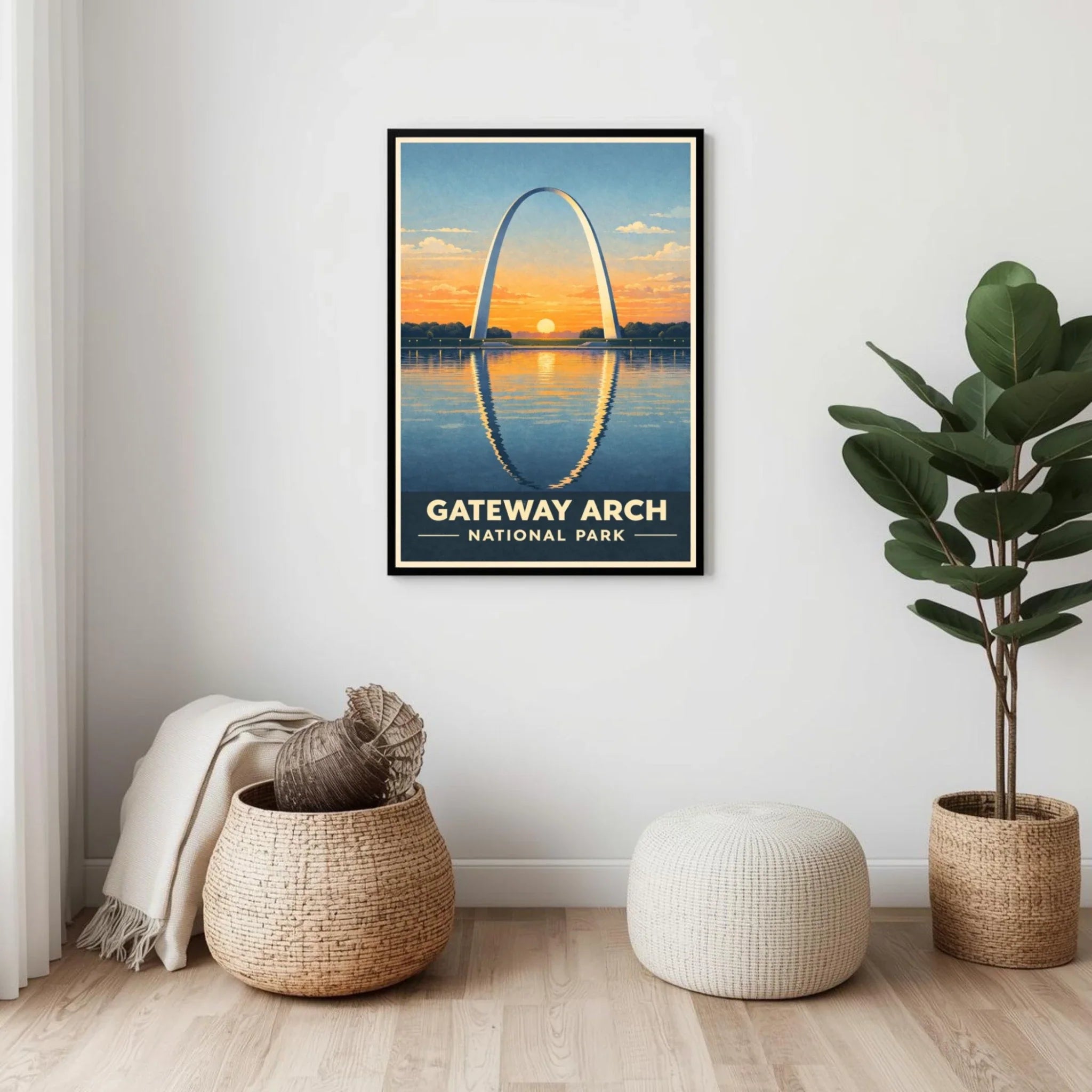 Framed poster of Gateway Arch National Park with decorative plants and a pouf on a wooden floor.