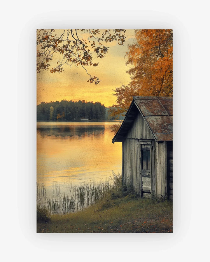 Painting of a wooden cabin by a lake at sunset with autumn trees.