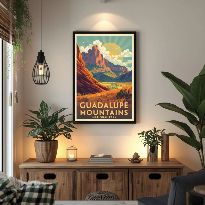 Framed Guadalupe Mountains National Park poster on a wall above a wooden cabinet with plants.