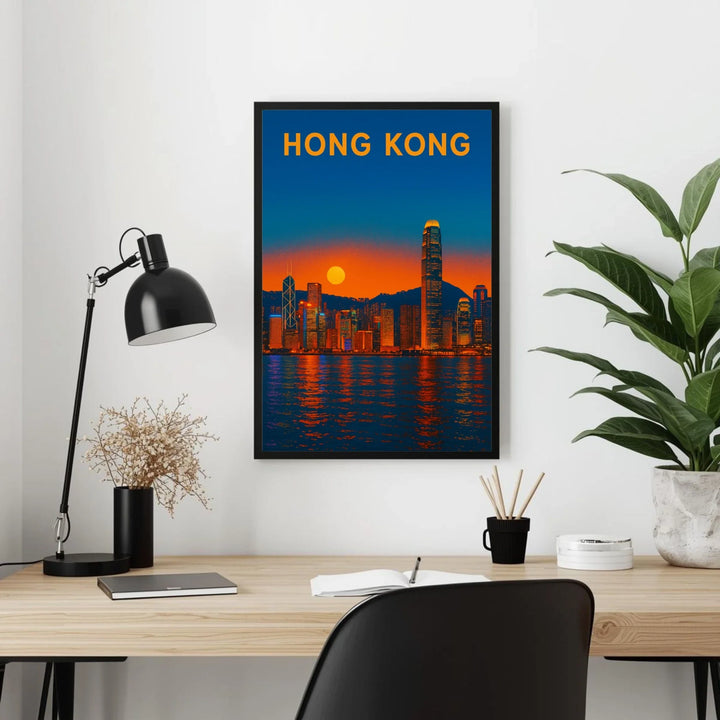 Framed poster of Hong Kong skyline on a wall above a desk with office items.