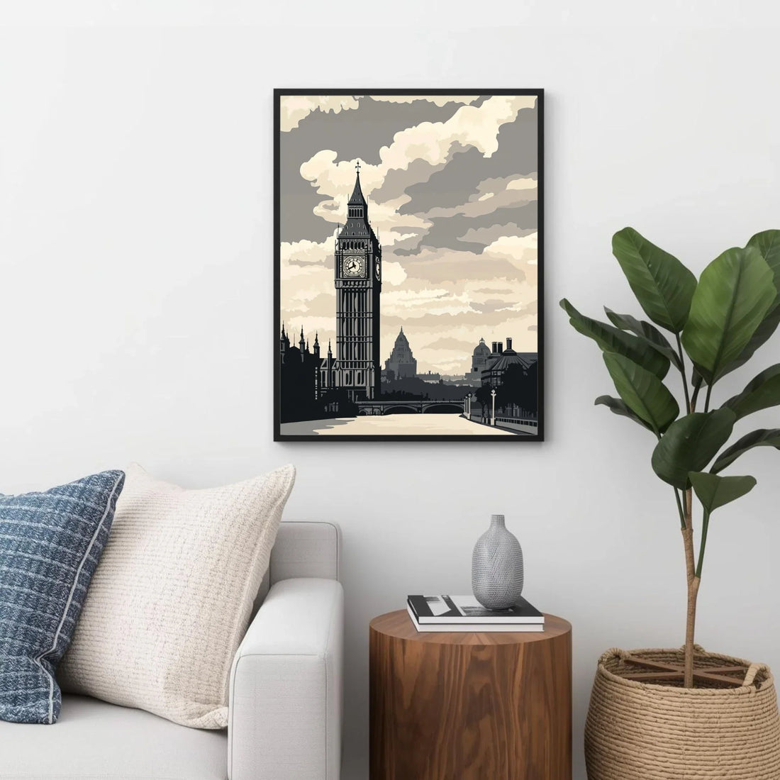 Framed artwork of a clock tower on a wall in a living room with a plant and side table.