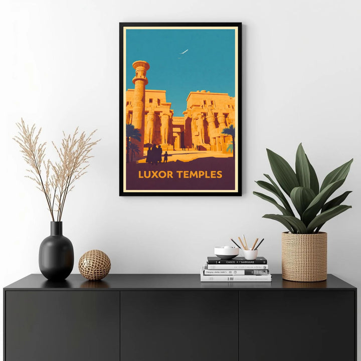 Framed poster of Luxor Temples on a wall above a black cabinet with decorative items.