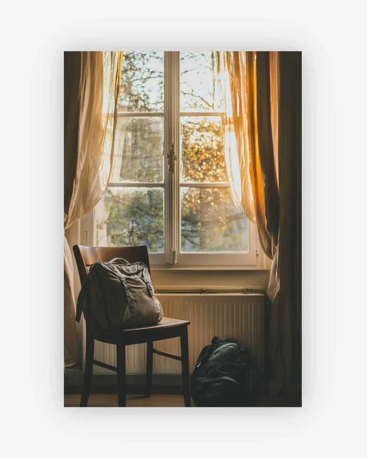 Chair with backpack near a window with curtains