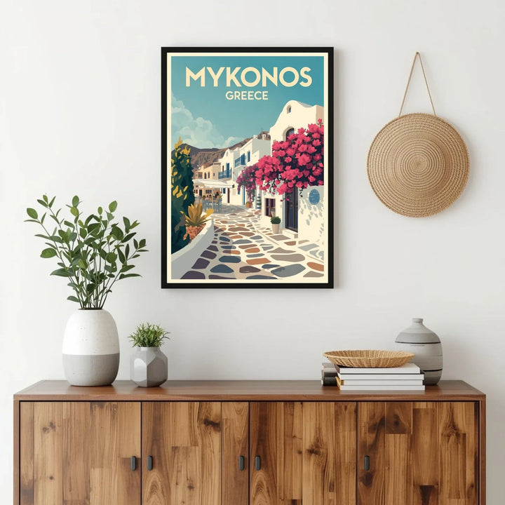 Framed poster of Mykonos, Greece on a wall above a wooden cabinet with decorative items.