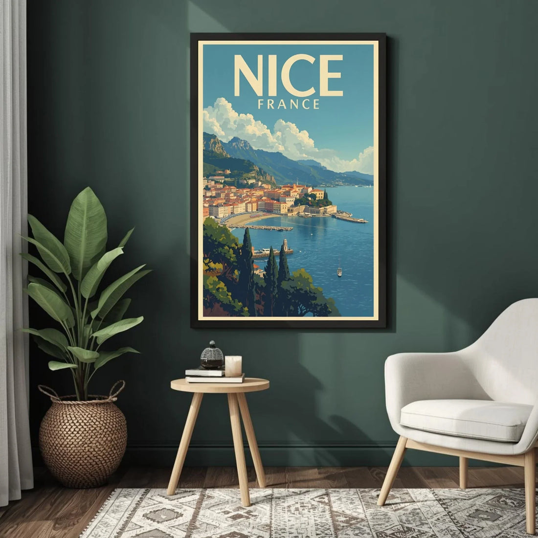 Framed poster of Nice, France on a dark green wall above a small table and chair.