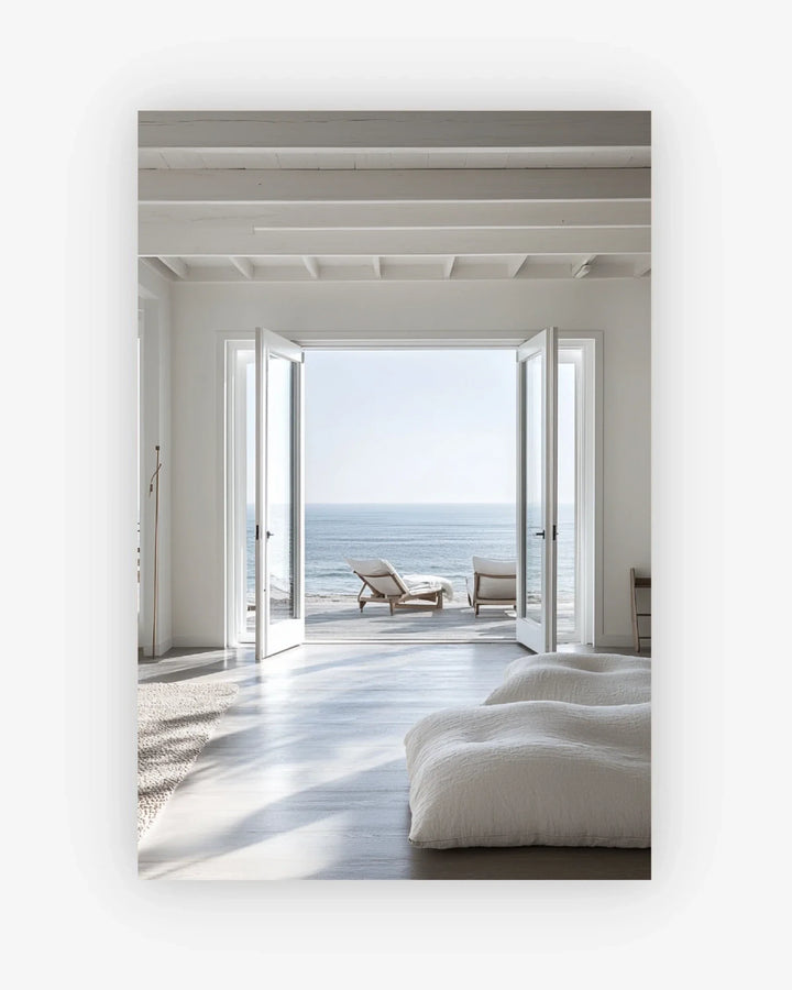 Modern interior with a view of the ocean through large open doors.