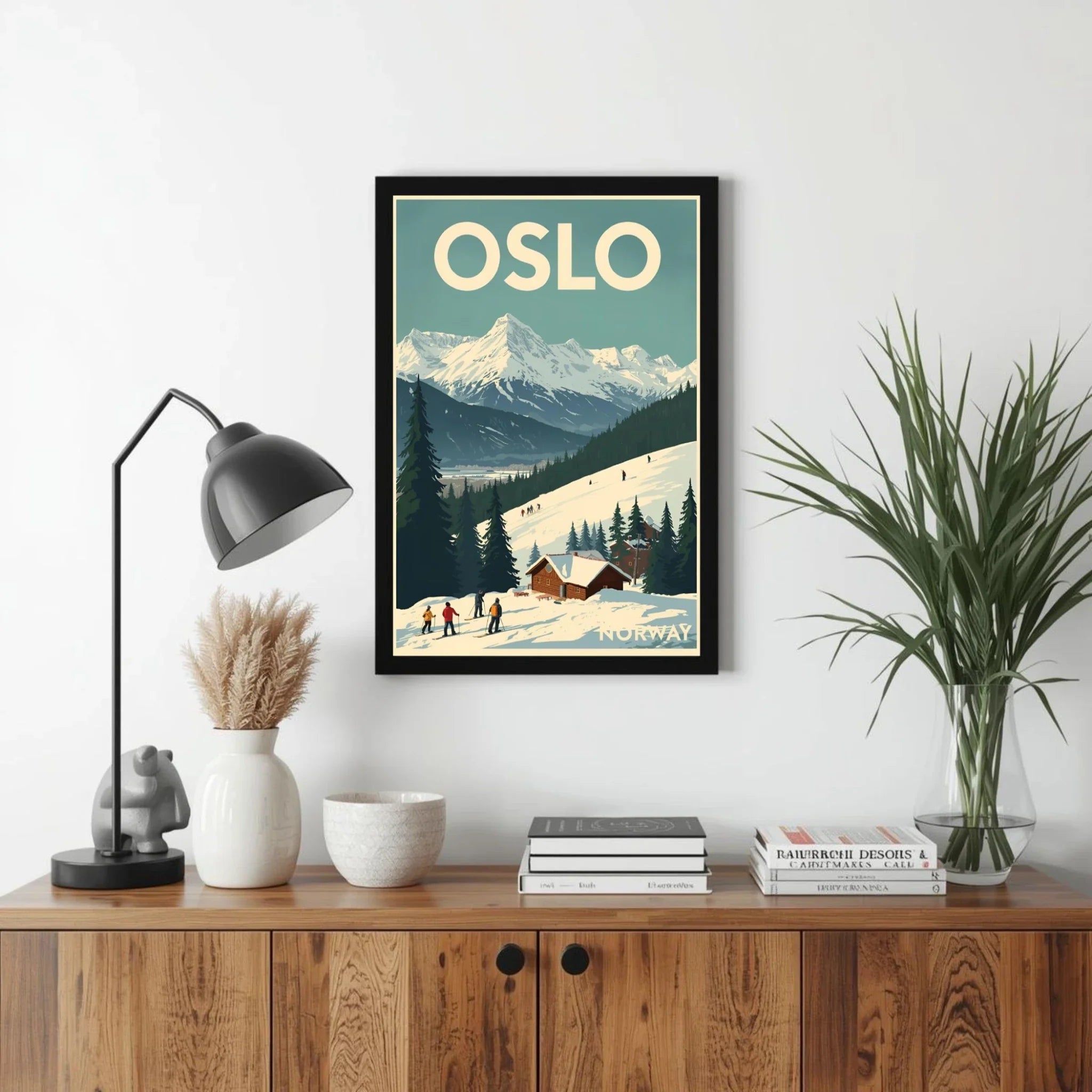 Framed poster of Oslo with a mountain view on a wall above a wooden cabinet.