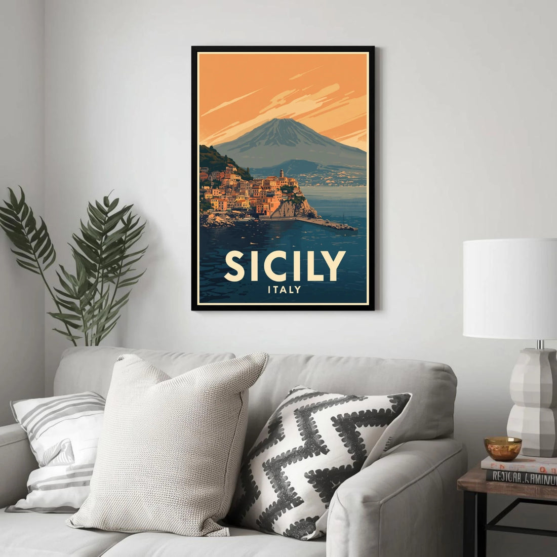 Framed poster of Sicily, Italy on a wall above a sofa with decorative pillows.