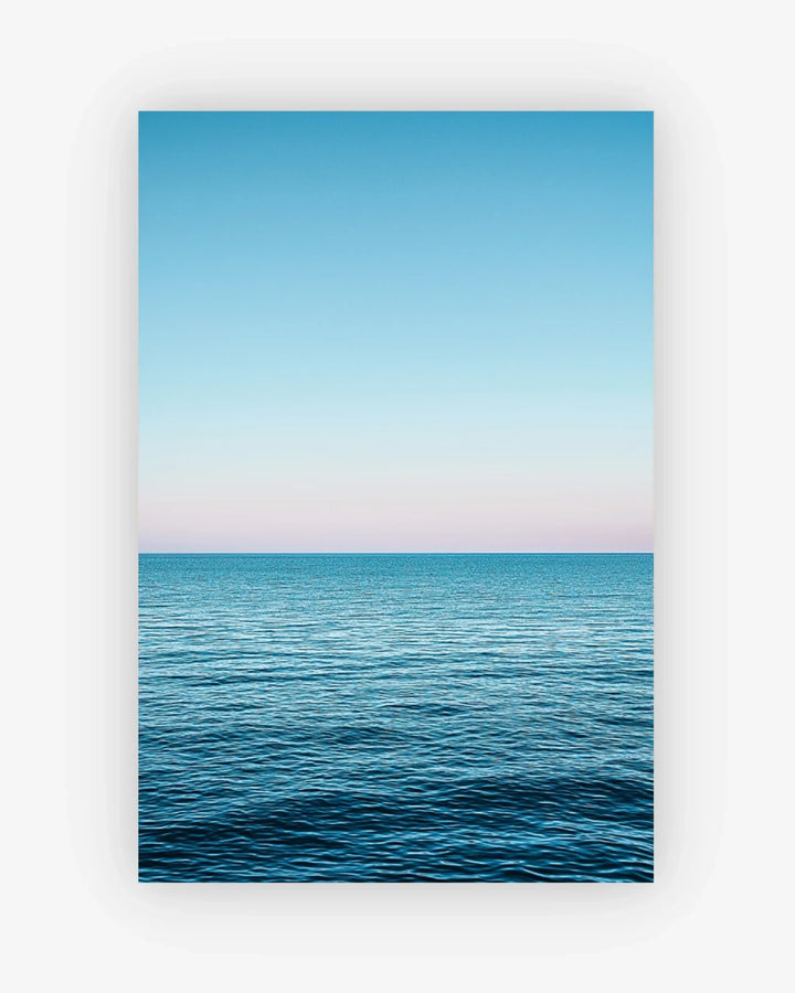 Framed artwork of a blue ocean and sky with a white frame.