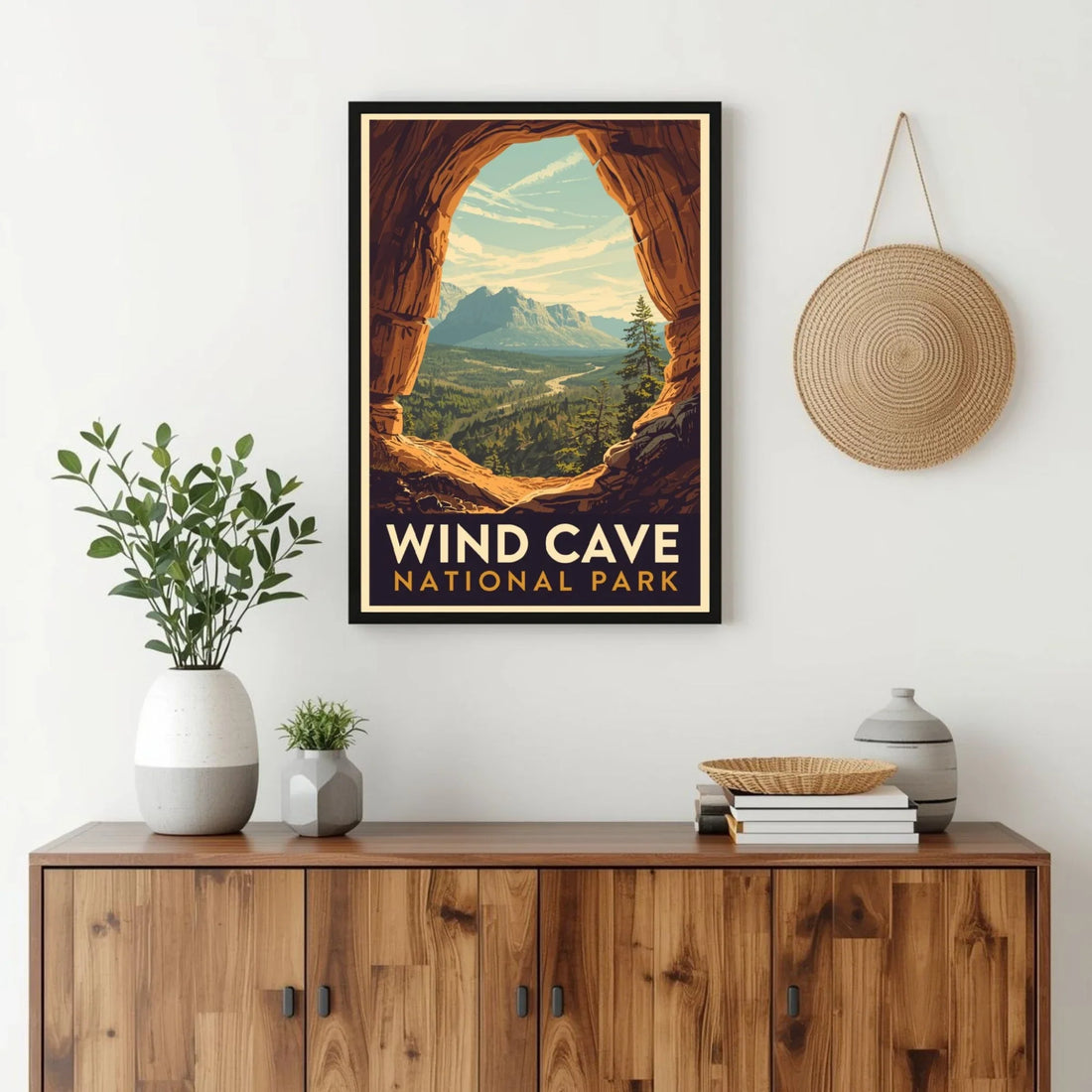 Framed poster of Wind Cave National Park above a wooden cabinet with decorative items.