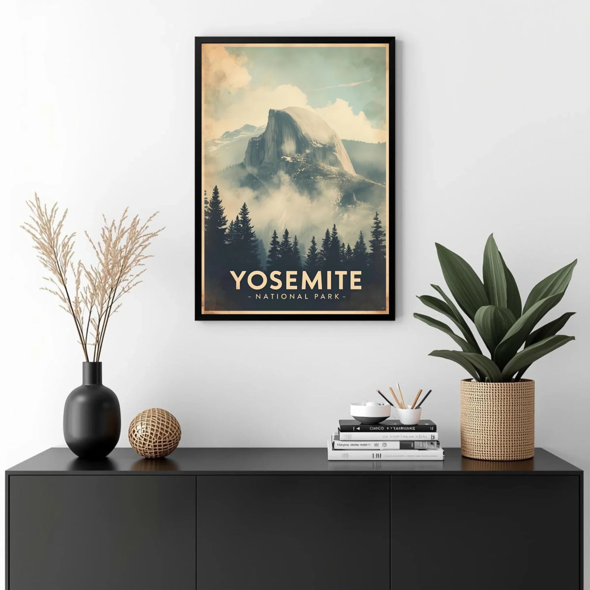 Framed Yosemite National Park poster on a wall above a black cabinet with decorative items.