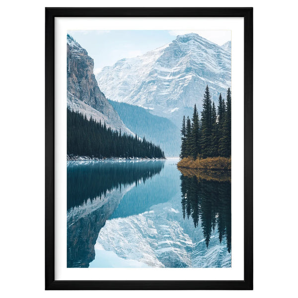 Banff Tranquility minimalist mountain artwork in a black frame leaning against an off-white wall, featuring mirrored alpine peaks and a still blue lake.