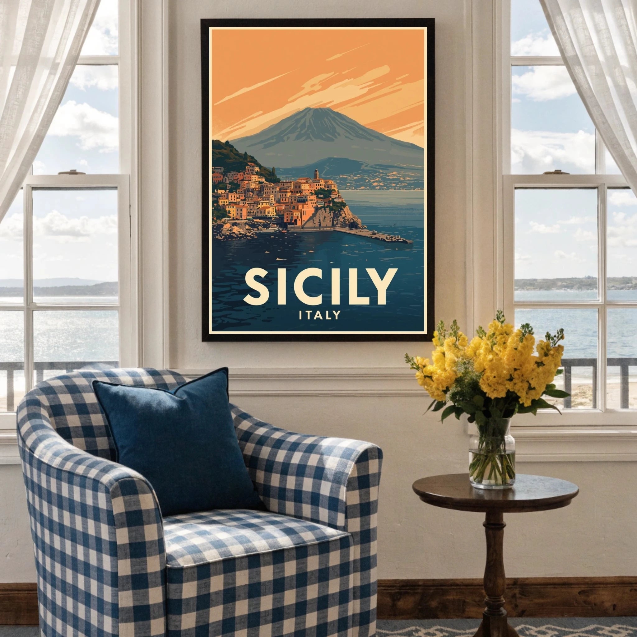 Framed poster of Sicily, Italy in a living room with a checkered armchair and flowers.